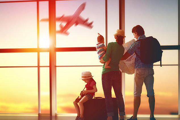 Image of family looking out of an airport window.