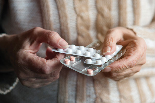 Close up image of hands holding medications.