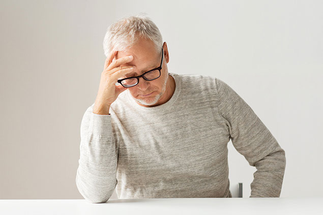 Image of man with hand on forehead.