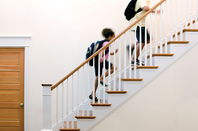 Image of 2 school kids running up the stairs.