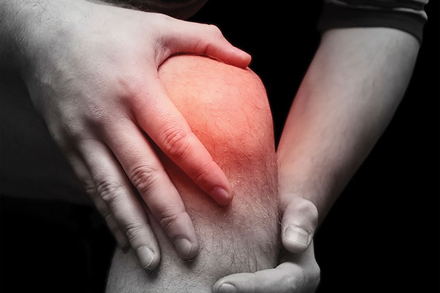 Close up image of man's knee in pain.