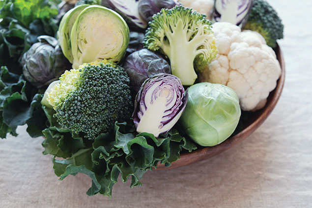 A bowl filled with broccoli and brussels sprouts.