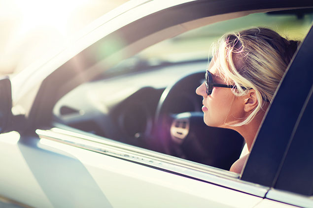 Teen sitting in driver seat of car.