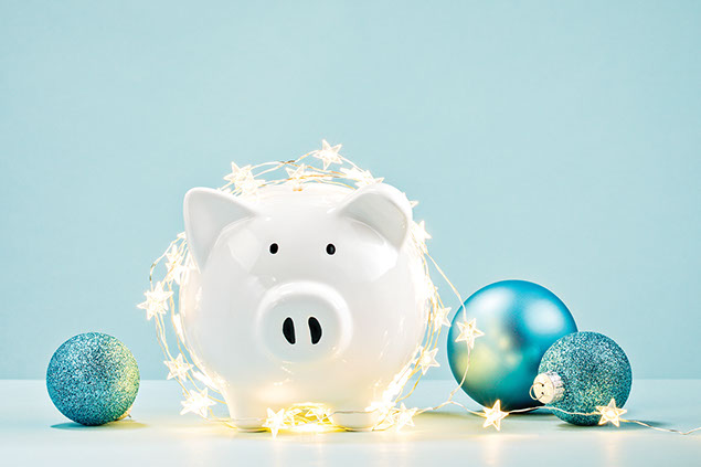 Piggy bank with holiday lights and ornments.