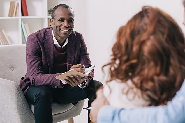 Smiling therapist talking to couple.