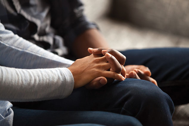 Close up of couple holding hands.