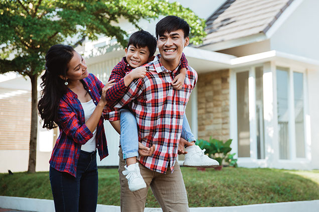 Image of young family outside of home.
