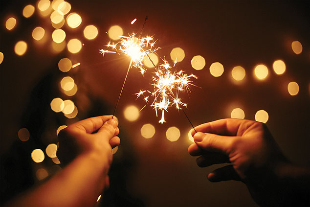 Two hands holding sparklers.