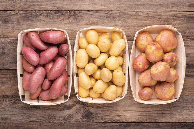 Three baskets filled with potatoes.