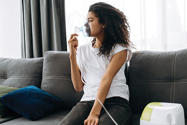 Women sitting with a portable oxygen mask.