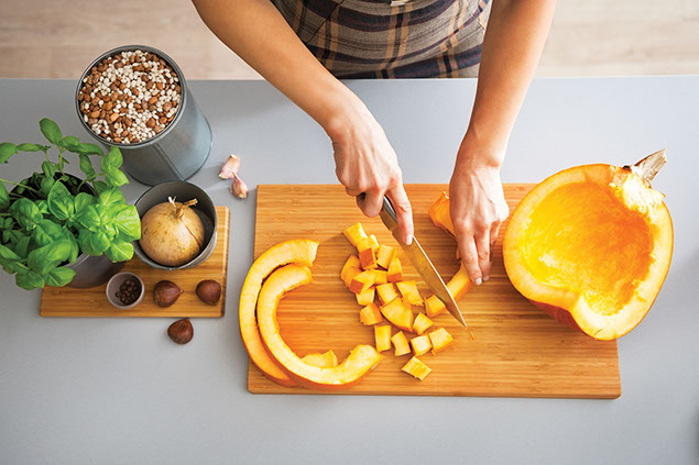 Bird-eyes view, cutting vegetable on a cutting board.