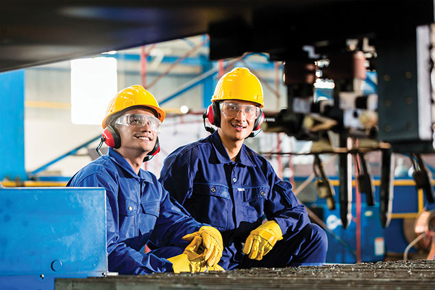 Workers with safety gear protecting head, eyes and ears.