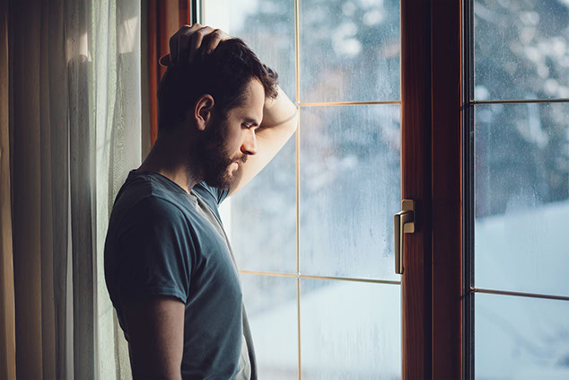 Man looking outside a window.