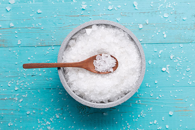 A bowl filled with salt and a wooden spoon.