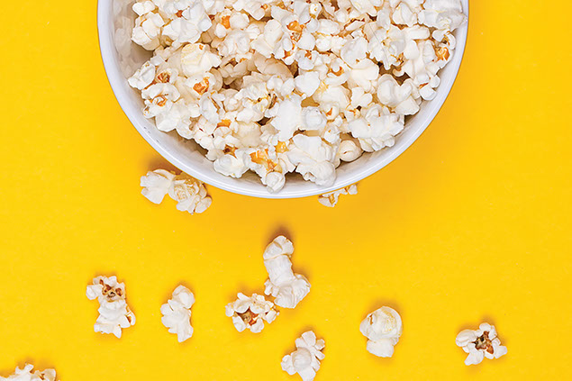 Popcorn in a bowl on a yellow background.