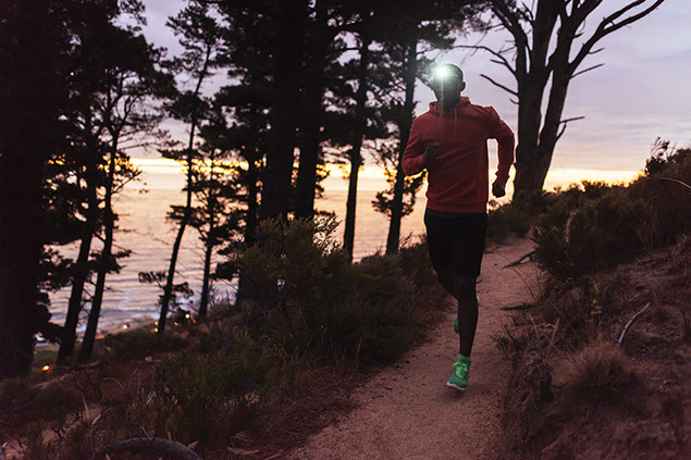 Man running at dusk with head light.