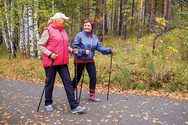 Two women walking with walking sticks.