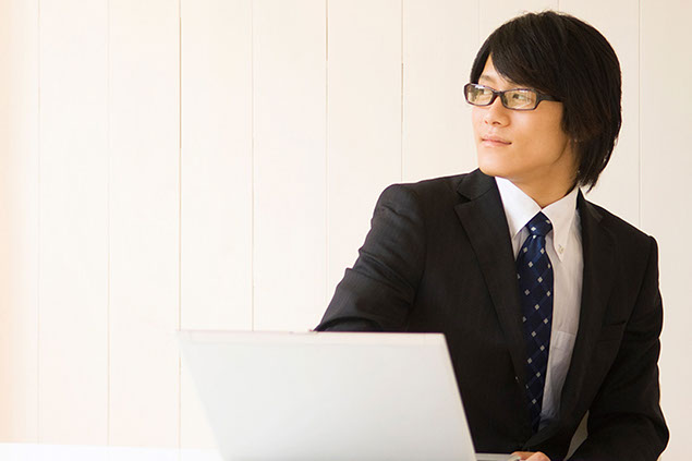 Image of man in suit with a laptop.
