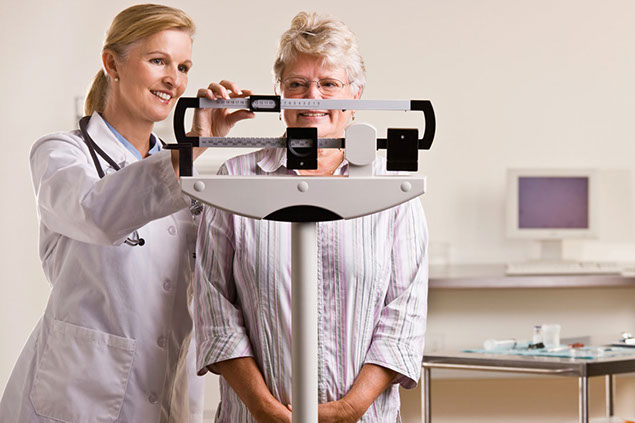 Image of patient on scale at doctor's office.
