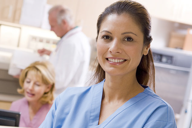 Image of nurse standing in front of the nurse station.