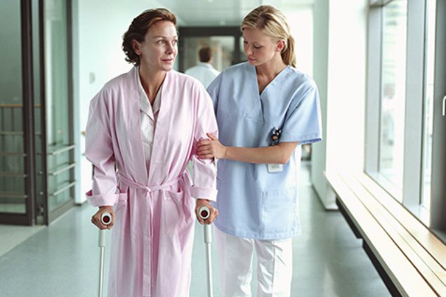Image of nurse helping a women walk.