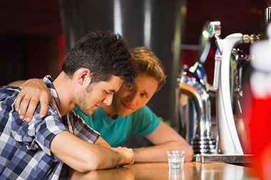 Image of 2 friends at a bar.