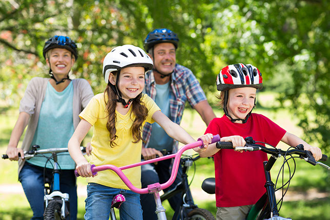 Image of family riding bikes with helmets on.