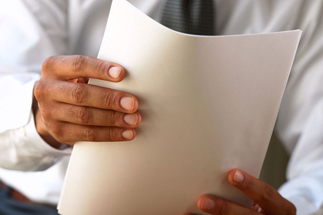 Close up image of hands holding paper.