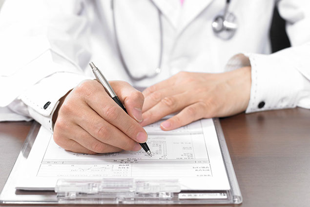 Close up image of hands filling out forms.