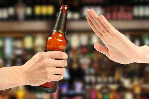 Image of hand refusing bottle of beer.