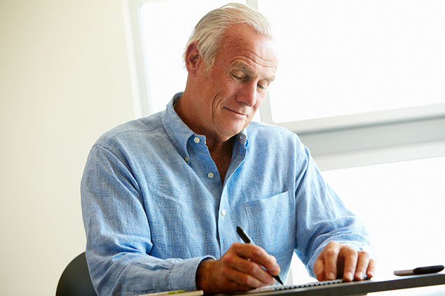Image of happy man writing.