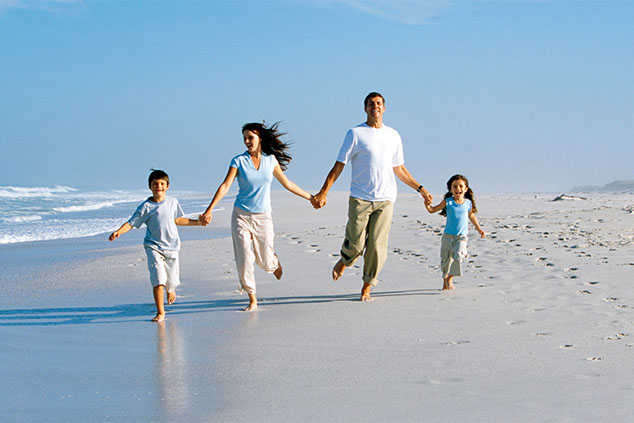 Image of family running on beach.
