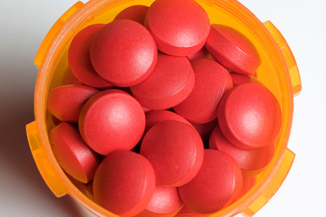 Image of red pills in a pill bottle.