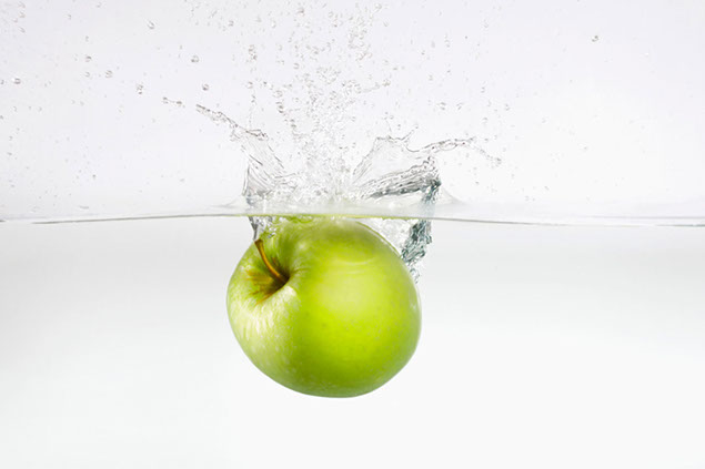 Apple splashing in water.