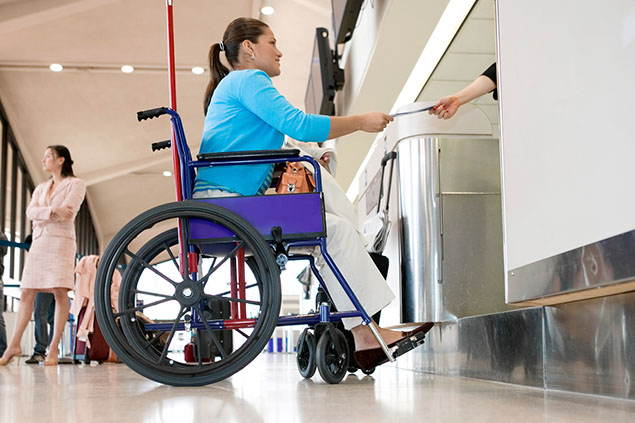 Women in wheelchair at airport check-in counter.