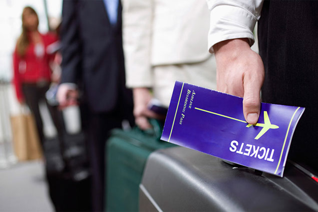Close up image of airplane ticket held in hand.
