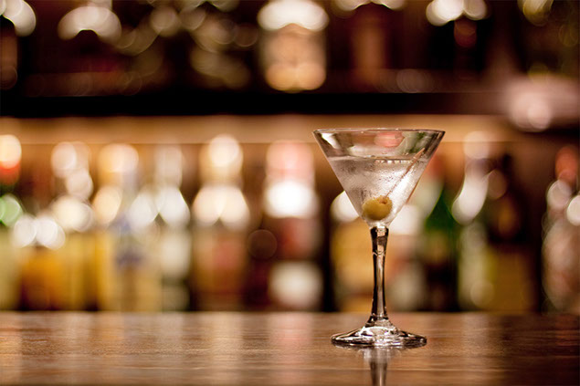 Image of a glass of alcohol on a bar counter.