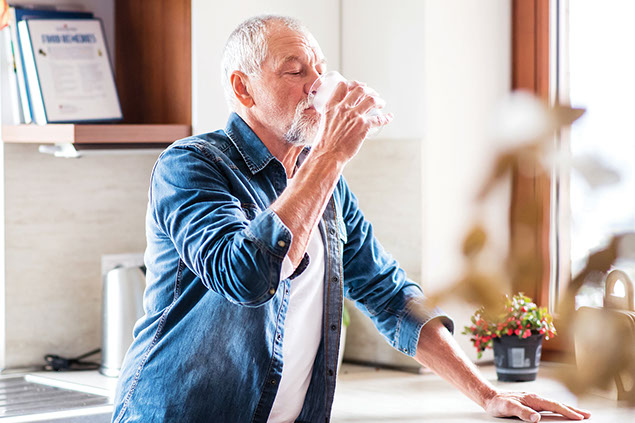 Man drinking a glass of water.
