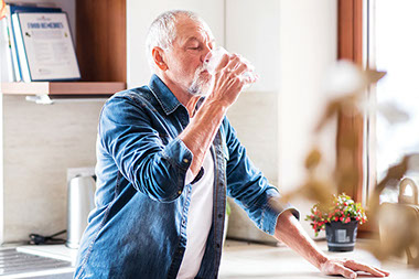 Man drinking a glass of water.