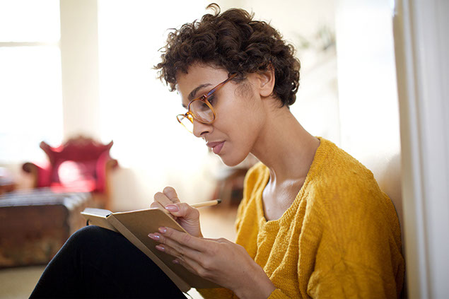 Women writing in notebook.