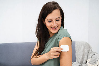 Women putting on a patch on arm.