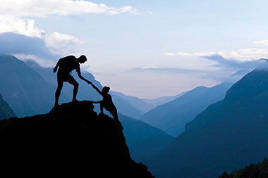 Two people climbing a mountain.