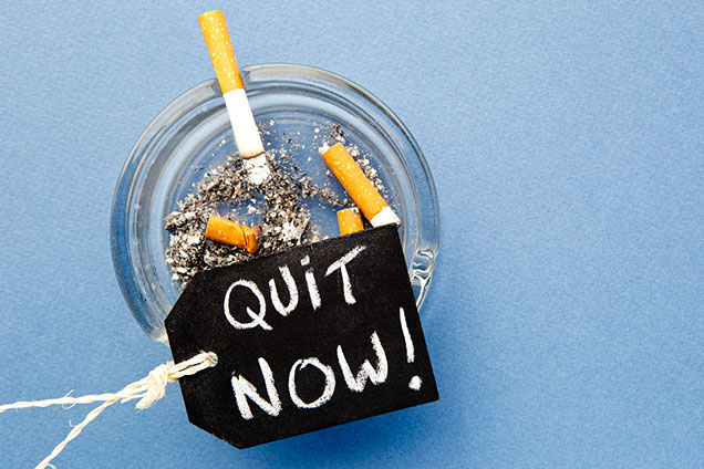 Image of quit now tag cigarettes in ashtray.