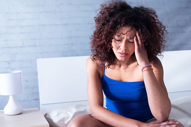 Image of women waking up with a headache.