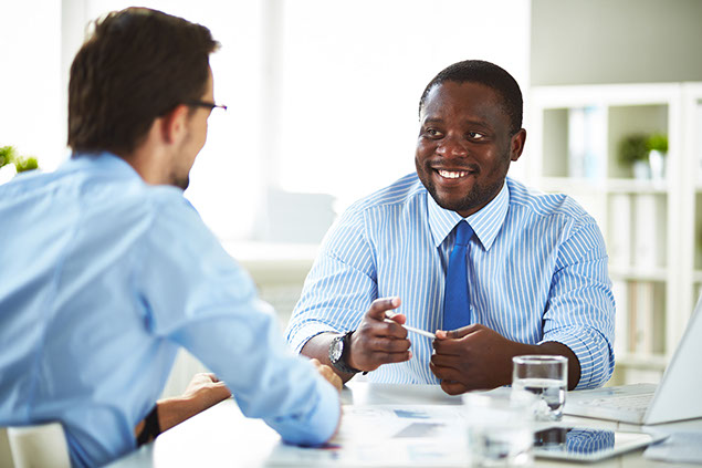 Image of 2 co-workers talking.